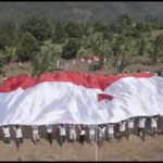 POLRI DAN EKS NAPITER BENTANGKAN BENDERA MERAH PUTIH RAKSASA DI GUNUNG BIRU POSO