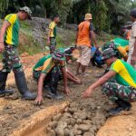 SATGAS PAMTAS YONARMED 11 KOSTRAD DAN WARGA GOTONG ROYONG PERBAIKI JALAN RUSAK DI DESA SEIKADUYAN TAKA